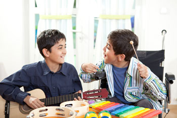 Zwei Kinder musizieren mit Gitarre und Xylophon