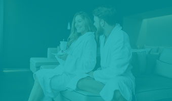 Gesundheitstourismus uebersicht Paerchen im Bademantel wartet im Wellnesshotel auf den Massagetermin