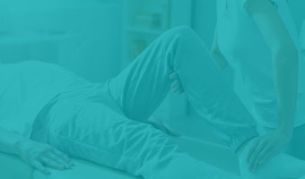 Physiotherapie uebersicht Physiotherapeutin behandelt Patienten und winkelt das Bein an