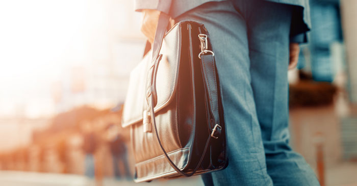 Ein Manager mit einer Aktentasche ist auf dem Weg zur Arbeit.