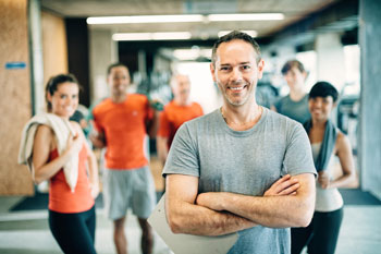 Fitness Trainer schauen lächelnd in die Kamera