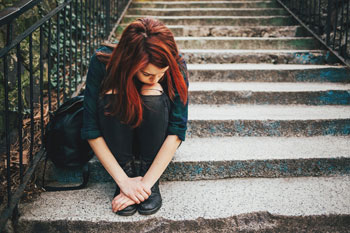Depressives Mädchen sitzt auf einer Steintreppe