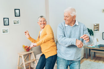 Ein Seniorenpaar berührt sich tanzend mit der Hüfte