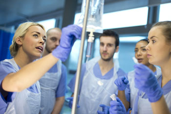 Medizinstudenten wird in einem Krankenhaus gezeigt, worauf bei einem Tropf geachtet werden muss