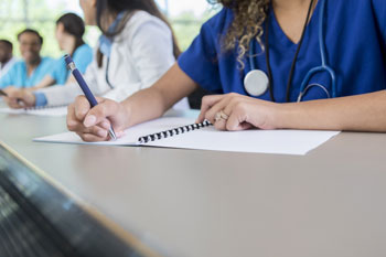 Eine Medizinstudentin macht sich im Unterricht Notizen